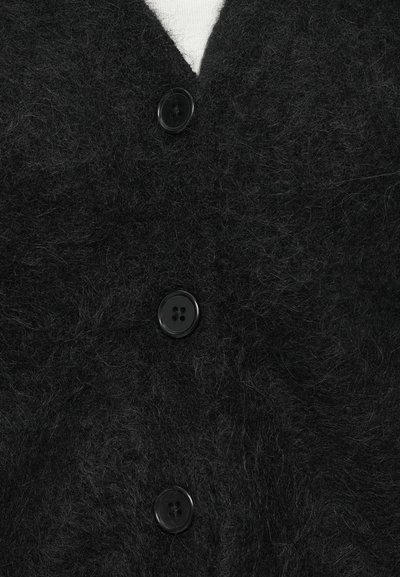 Cardigan preto felpudo com decote em V, três grandes botões pretos e uma superfície macia e texturada. Sem padrões ou acentos visíveis.