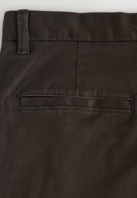 Pantaloni in tessuto marrone scuro con una texture liscia, dotati di una tasca posteriore piatta e un sottile dettaglio di cucitura lungo le cuciture.