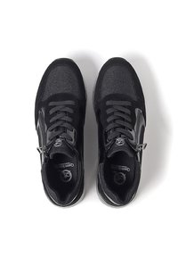 Baskets noires avec un tissu texturé et des accents en cuir lisse, lacets ronds et fermeture éclair sur le côté.