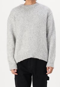 Maglione grigio a maglia con scollatura rotonda rigata, spalle abbassate e orlo posteriore più lungo. Realizzato in un materiale morbido e testurizzato.