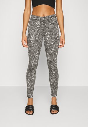 Leggings com padrão de cobra em preto e branco, com um design justo, apresentando uma cintura elástica e uma textura suave e elástica.