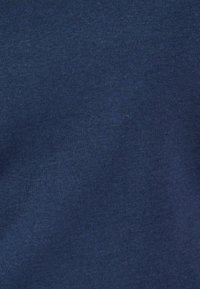 Tessuto blu navy con una superficie liscia, caratterizzato da un motivo a coste uniforme. Nessun motivo visibile o dettagli hardware.