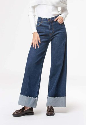 Jeans a gamba larga di colore blu scuro con orlo grezzo, con dettagli a risvolto di colore blu chiaro. Realizzati in denim con un classico design a cinque tasche.