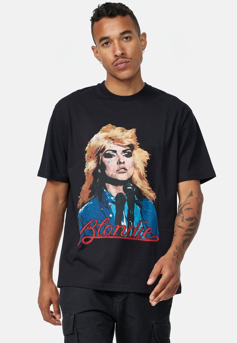 Černé bavlněné tričko s vintage grafikou ženy se světlými vlasy a mikrofonem, na které je překryto textem "Blondie" v červené barvě.