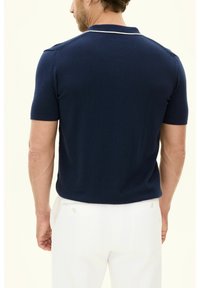 Marineblauwe polo met korte mouwen van gehaakt textiel, met een witte kraagrand en een soepele afwerking. Eenvoudige achteraanzicht weergegeven.