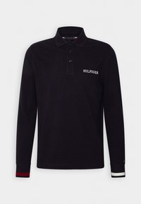 Svart långärmad pikétröja med treknapps knäppning, broderad "HILFIGER"-logotyp och randiga detaljer på ärmsluten i röd och vit.