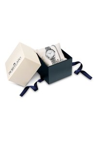 Orologio in tonalità argento con quadrante rotondo, dial bianco e cinturino in metallo con motivo, esposto su un cuscino crema in una scatola regalo nera con nastro blu navy.