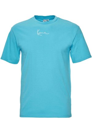 Light blue cotton t-shirt with short sleeves and a crew neck, featuring a white signature logo on the front. Smooth texture, casual fit.