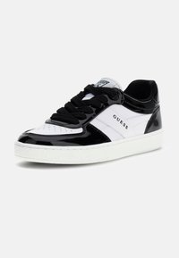 Czarnobiały trampek z lakierowanym wykończeniem, z okrągłym noskiem, czarnymi płaskimi sznurowadłami i białą teksturowaną gumową podeszwą. Logo marki na boku.