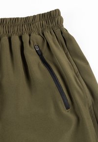 Oliwkowe spodnie sportowe z elastycznym paskiem w talii, boczną kieszenią na zamek i gładkim, lekkim materiałem. Posiadają marszczoną teksturę w pasie.
