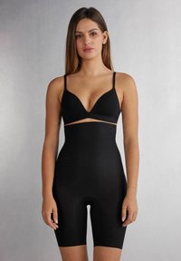 Zwarte bodysuit met een diepe decolleté en minimalistische bandjes. Gladde textuur, figuurvormend ontwerp en lengte tot halverwege de dijen.