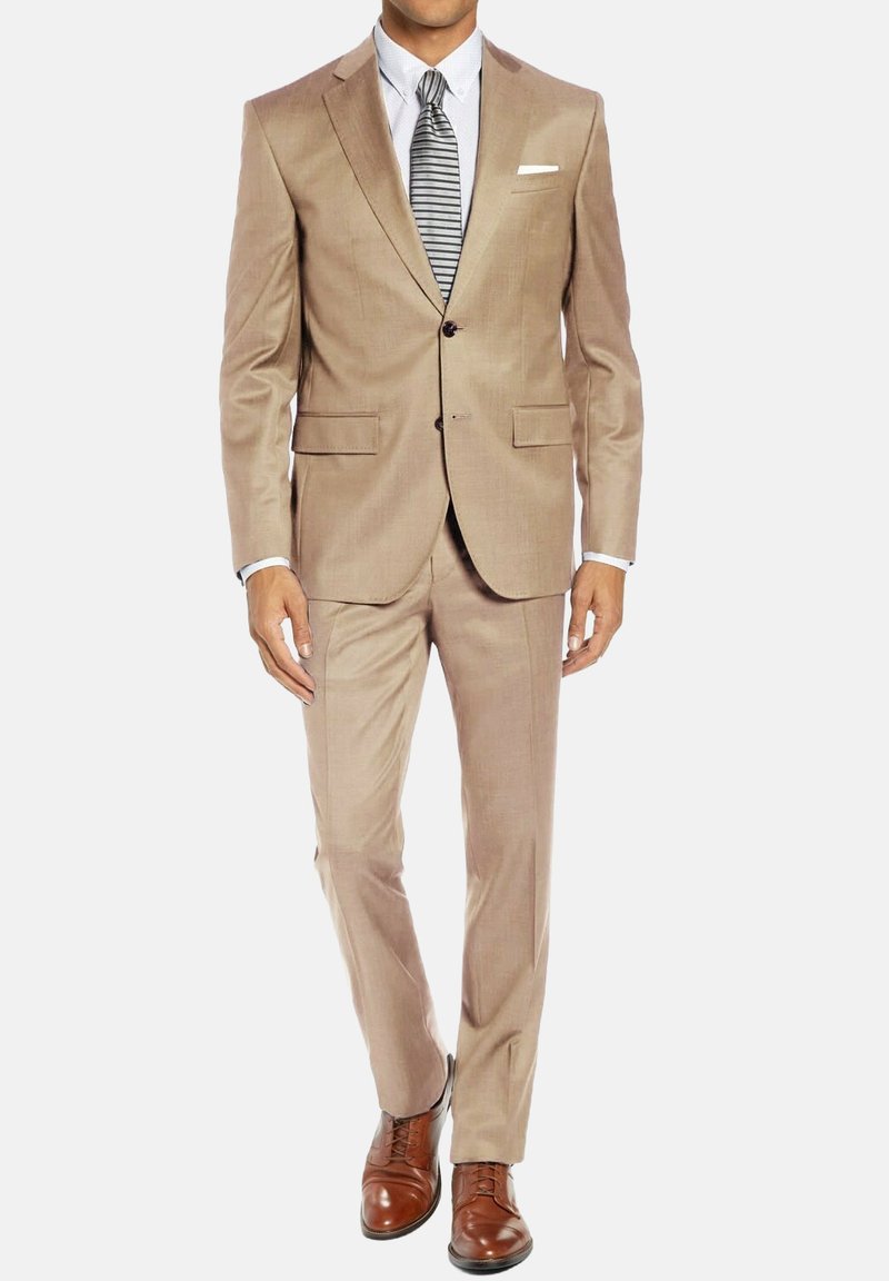 Costume beige ajusté avec deux boutons, revers crantés et poches latérales. Associé à une chemise blanche, une cravate rayée et des chaussures en cuir marron.