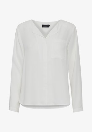 Hvit langermet bluse med V-hals, frontlomme, glatt tekstur og avrundet søm. Merkelappen "oxmo" er synlig inne i kragen.