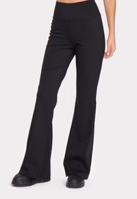 Črne, razširjene legice z visokim pasom, narejene iz elastične tkanine, z ravnimi šivi in gladko, mat teksturo.