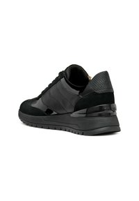 Zapatilla negra con una mezcla de cuero patentado suave y acentos de ante texturizado. Presenta un perfil bajo, suela gruesa y diseño de cordones.