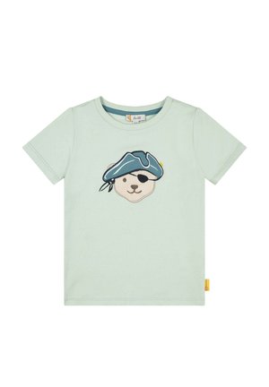 Camiseta de algodón verde claro con un diseño bordado de la cara de un oso que lleva un sombrero de pirata azul y un parche en el ojo, con una pequeña etiqueta amarilla en el lado.