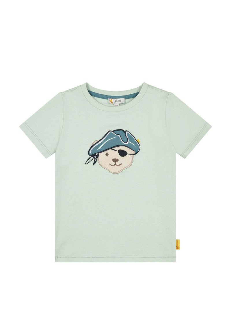 Camiseta de algodón verde claro con un diseño bordado de la cara de un oso que lleva un sombrero de pirata azul y un parche en el ojo, con una pequeña etiqueta amarilla en el lado.