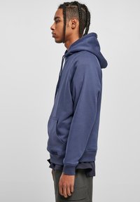 Sudadera con capucha azul marino en tejido de mezcla de algodón, con un bolsillo tipo canguro, puños y bajo acanalados, con un ajuste relajado y capucha con cordón.