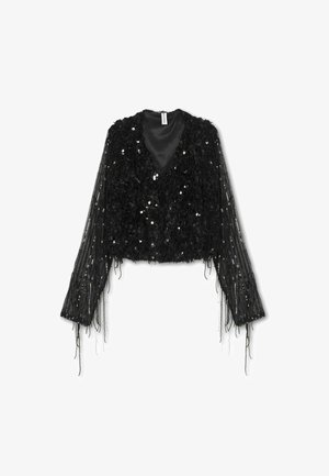 Črna kratka jakna z teksturirano zlatom spredaj, dolgimi prosojnimi rokavi in resicami. Oblika V-izreza s satenskimi podlogami.