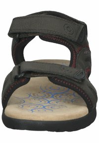 Sandales marron foncé avec deux sangles Velcro ajustables, dessus synthétique texturé et semelle intérieure rembourrée ornée de motifs en spirale bleus.