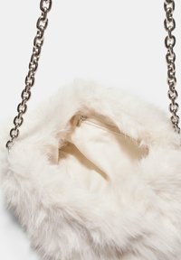 Faux fur taske i off-white med en sølv kædetræk. Indersiden er foret med blødt stof og har en lynlåslomme.