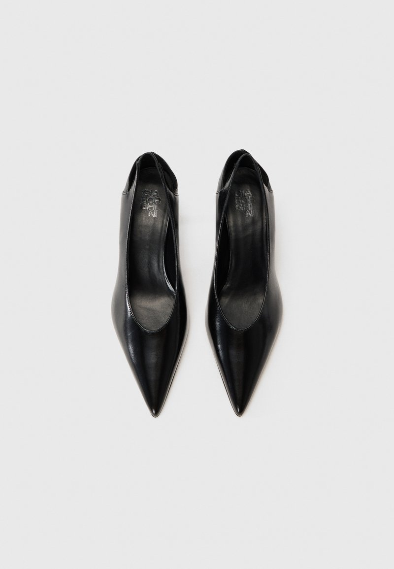 Schwarze, lederne Slingback-Absätze mit spitzer Zehenform, die über eine glatte Textur und offene Seiten verfügen, sowie geprägt mit Branding auf den Innensohlen.