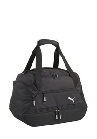 Black duffel bag made of durable fabric, featuring two zippered pockets, sturdy handles, and a white Puma logo. Spacious design with a textured finish.