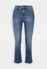 Ljust blå denimjeans med en åtsittande överdel och utsvängda nederdelar. Har en klassisk design med fem fickor och knäppning i midjan.