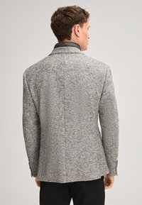Grau kariertes Tweed-Sakko mit strukturiertem Muster, Reverskragen, schmaler Passform und geknöpften Manschetten. Die Rückseite zeigt saubere Nahtlinien und einen Schlitz.