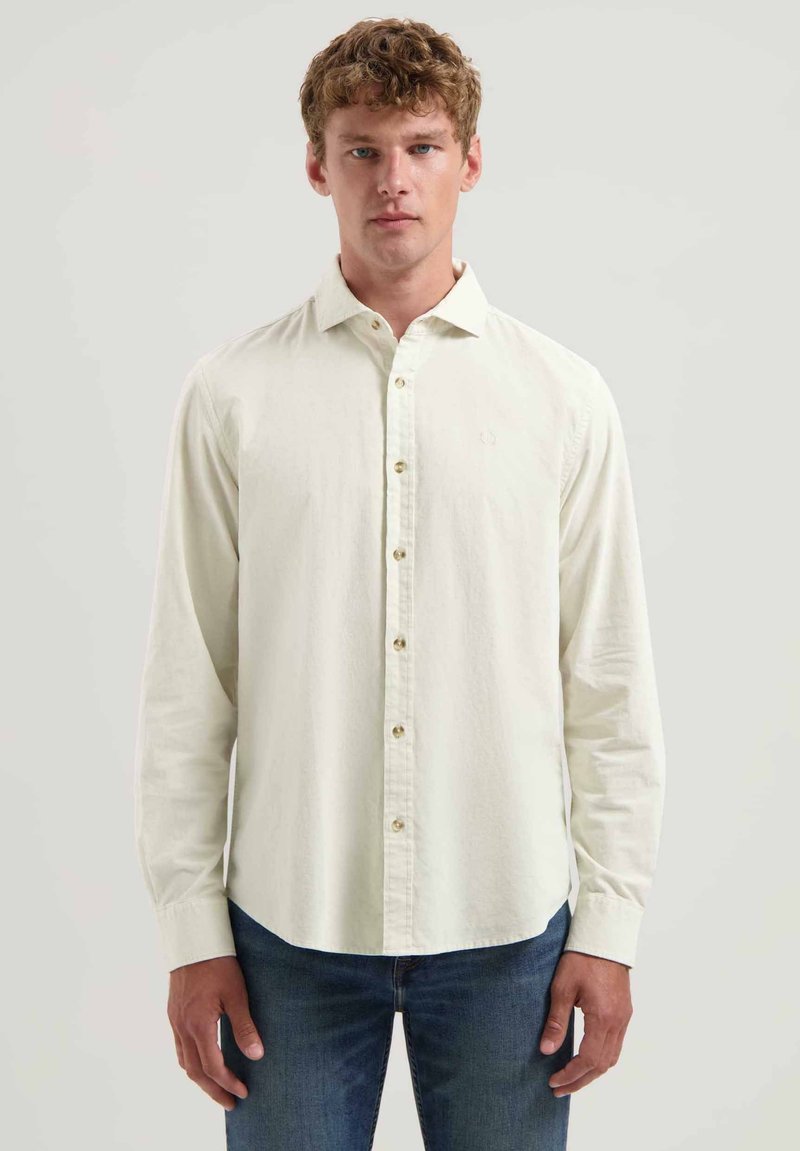 Helebeež pikkade varrukatega särk nööbiga kraega ja peene tekstuuriga, slim fit'i lõikega ja ühe rinnataskuga, sobitatuna teksadega.
