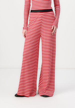 Red and white striped wide-leg pants with a black waistband and long sleeves, made from a soft, stretchy fabric.