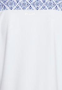 Bílý top s modrým květinovým vzorem v oblasti výstřihu. Obsahuje logo "RLX" v bílé barvě. Hladký materiál, ležérní design.