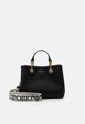 Black leather handbag with gold metal accents and short handles, featuring a detachable white strap with large Emporio Armani logo.