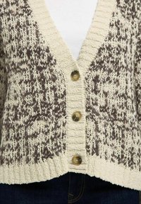 Strickjacke mit einem creme- und braunfarbenen Muster, strukturiertem Stoff, V-Ausschnitt und drei großen Knopfverschlüssen. Gerippter Saum.