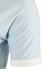 Camisa de manga corta azul claro con dobladillo blanco. Tejido suave con ligero brillo, que muestra un corte clásico y líneas limpias.