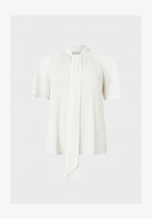 Fehér rövid ujjú blúz ráncolt elejű és egy hosszú, keskeny nyakkendőt lóg a közepén.