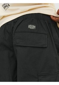 Schwarze Cargoshorts mit einem elastischen Bund, ausgestattet mit einer aufgesetzten Tasche auf der Rückseite und einem Markenschild, aus einem strukturierten Stoff gefertigt.