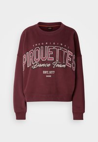 Μπορντό κοντομάνικο φούτερ με μακριά μανίκια. Διαθέτει την επιγραφή "Pirouettes Dance Team" σε έντονα λευκά και ασημένια γράμματα. Απαλή υφή.