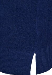 Gros plan sur un tissu en maille bleu marine avec un ourlet côtelé et un petit détail d'ourlet à la base.