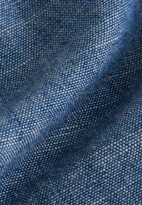 Tissu tissé bleu avec un motif texturé, présentant un mélange de fils foncés et clairs pour une profondeur. Apparence lisse, flexible et durable.