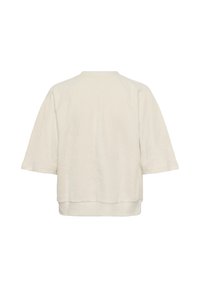 Pull à manches courtes couleur crème avec un motif de feuilles texturé subtil et un large ourlet en bas, vu de dos.
