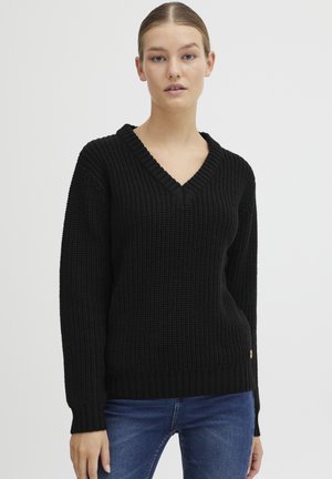 Maglione nero a maglia con scollo a V, polsini e orlo a coste. Presenta un motivo testurizzato e un piccolo logo in evidenza vicino al fondo.