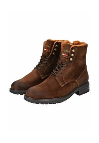 Botas de tobillo de ante marrón con forro de pelo sintético, ojales de metal y una suela de goma texturizada y resistente. Presenta detalles de costura y logotipo.