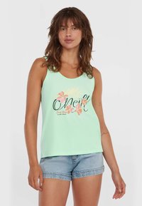 Mintgrünes Tanktop mit rundem Ausschnitt, blumigem Druck mit rosa Blumen und schwarzem Text. Kombiniert mit Denim-Shorts.