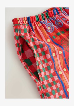 Färgglada, mönstrade tygshorts med elastisk midjeband. Har röda, gröna och rosa rutor samt abstrakta mönster i klara färger.