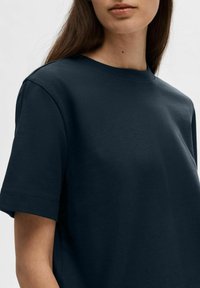Navy blue cotton t-shirt with a crew neck, short sleeves, and a relaxed fit. Features smooth texture and subtle stitching details.