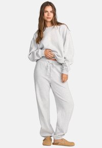 Helles graues Sweatshirt und passende Jogginghosen aus einem weichen Baumwollmix. Der Pullover hat gerippte Bündchen, während die Hose eine verstellbare Kordelzug-Taille hat.