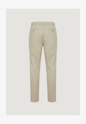 Beżowe, dopasowane spodnie z elastycznym paskiem w talii, dwiema zapinanymi na guziki tylnymi kieszeniami oraz prostym krojem nogawek, widoczne od tyłu.