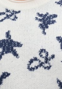 Tissu tricoté blanc avec des étoiles de mer bleu foncé et des motifs abstraits inspirés de la mer tissés dans le matériau.
