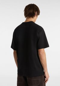 Camiseta de algodón negra de manga corta, cuello redondo y un corte relajado. Presenta un diseño liso sin patrones ni elementos visibles.